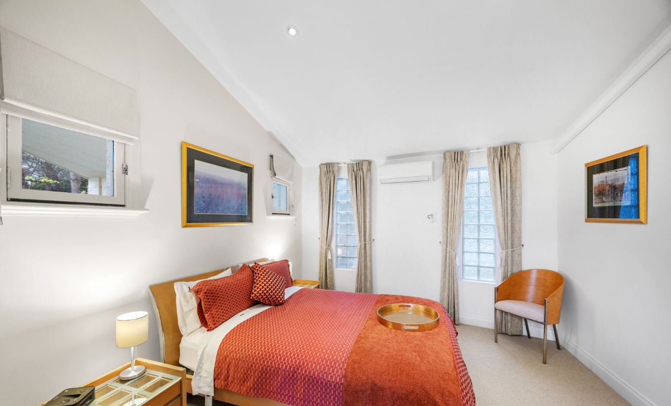 Queen-sized bed in the Melba Suite with warm copper accents