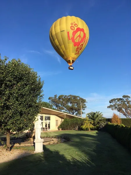 Hot air balloon passing above the Villa Capra lawn and statuary