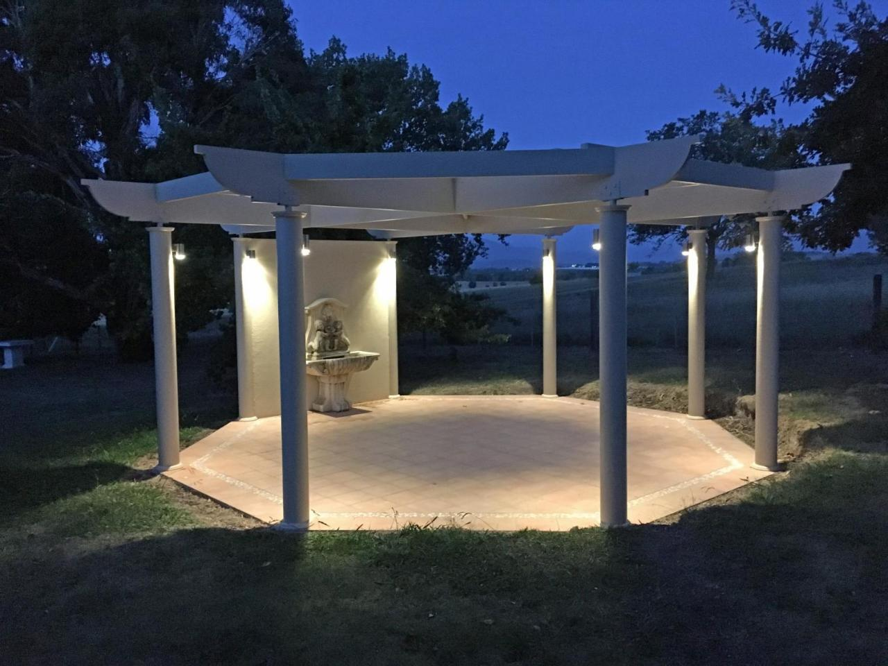 Illuminated pergola and fountain at dusk