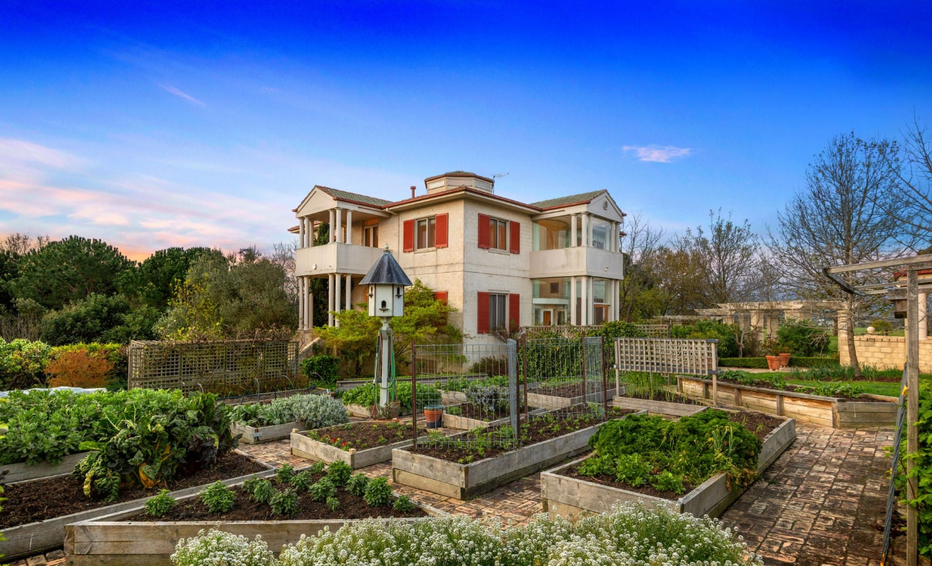 The Villa Capra house and vegetable garden beds at dusk